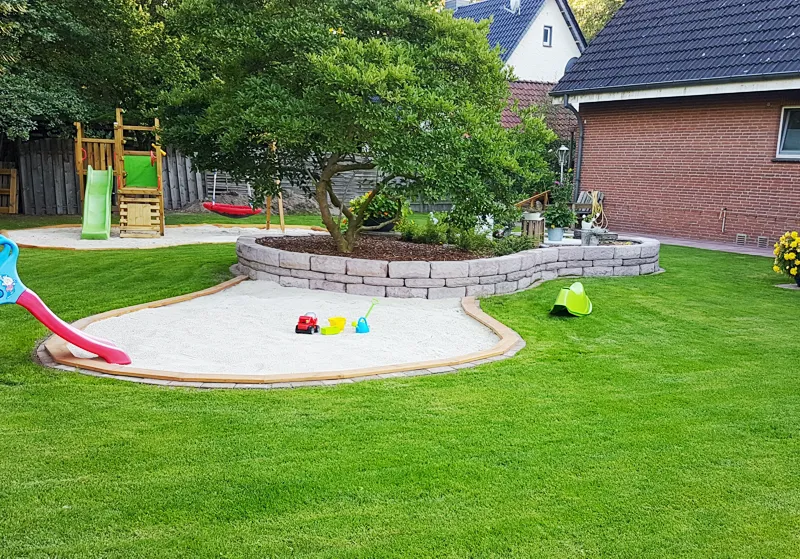 Großer Garten mit natürlichen Spielmöglichkeiten, Terrasse und sicherem Außenbereich für tägliche Naturerlebnisse