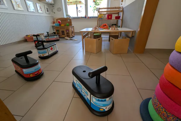 Spielzimmer mit Rutschautos und Fahrzeugen für motorische Entwicklung und Bewegungsspiele