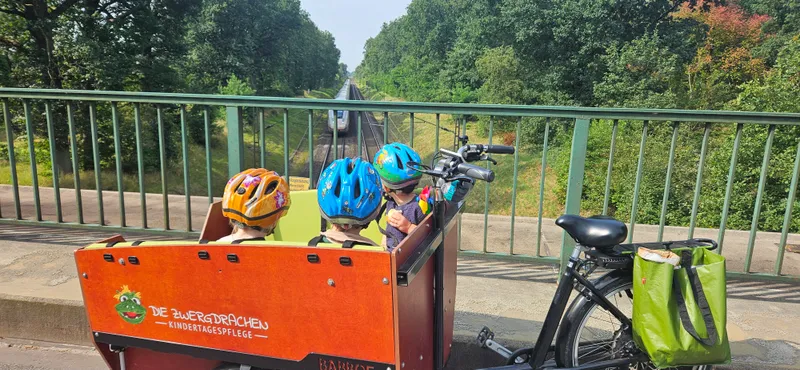 Kinder beim gemeinsamen Ausflug mit dem Krippenfahrrad – täglich draußen unterwegs