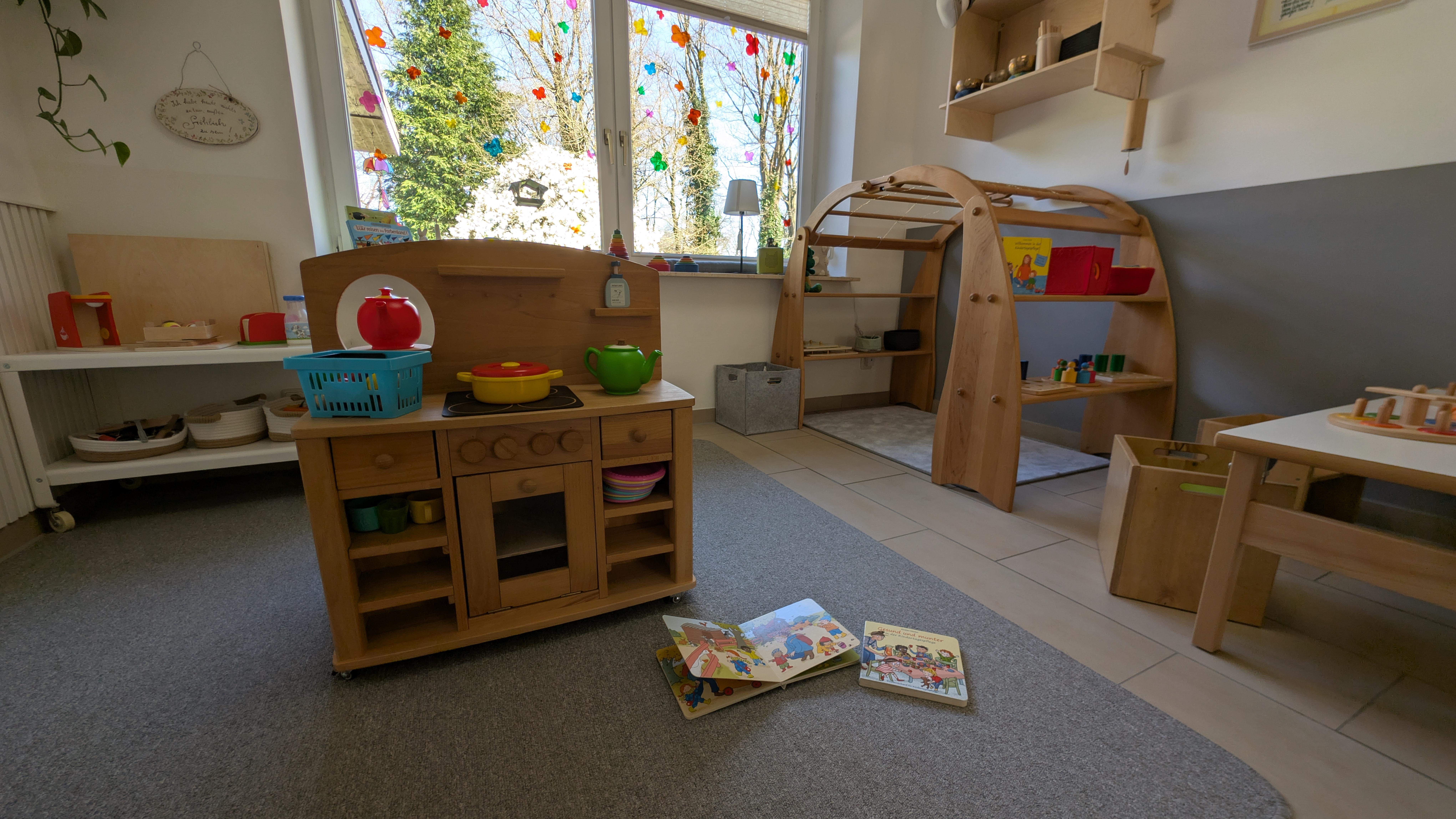 Kinderfreundlicher Spielbereich mit Holzküche, Lernmaterialien und natürlichen Spielzeugen für entwicklungsförderndes Spielen