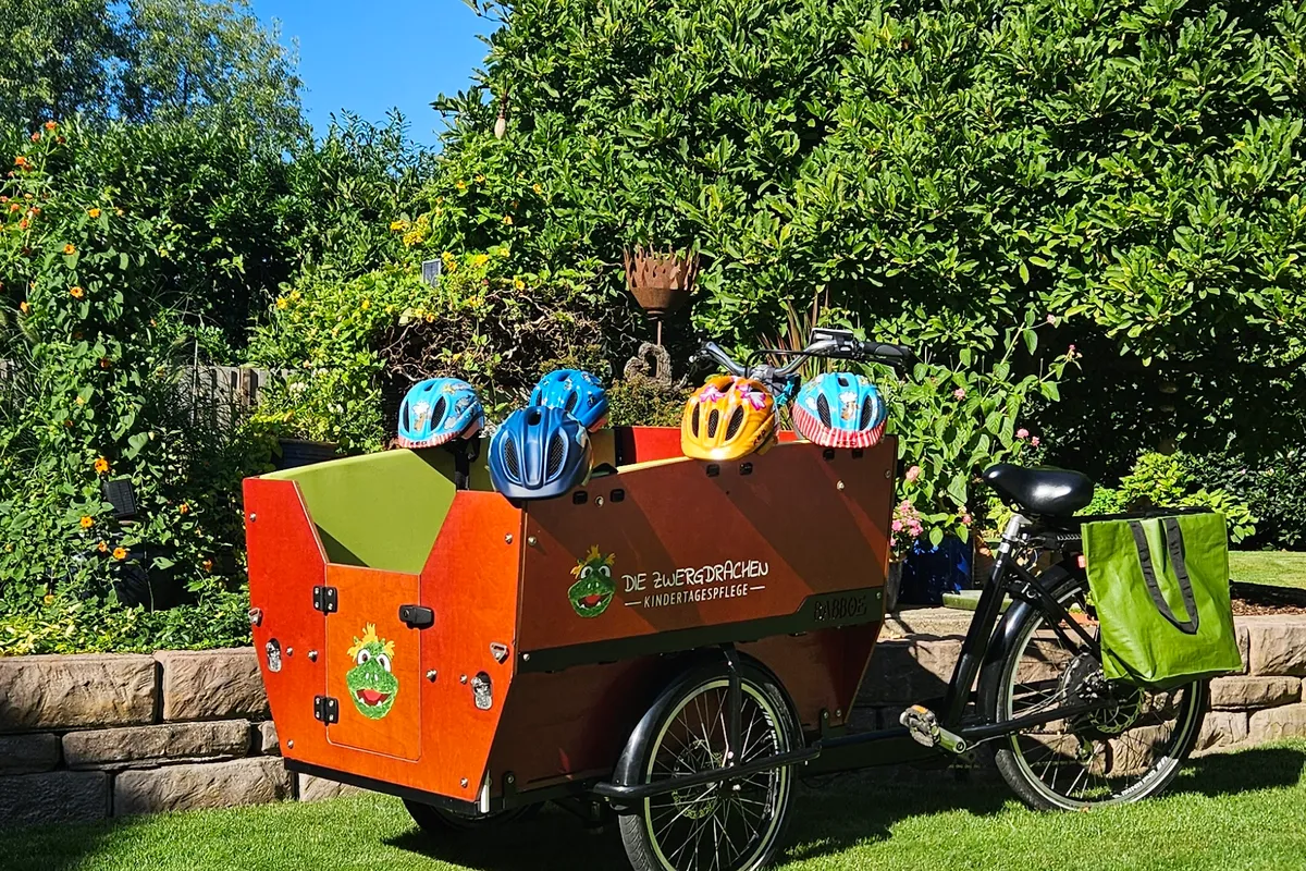 Lastenrad im Garten mit Kinderhelmen – Sichere Ausflüge und Mobilität in der Kindertagespflege Die Zwergdrachen