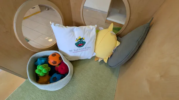 Bewegungsbereich mit weichen Kissen und Bällen für sichere Tobespiele und motorische Förderung