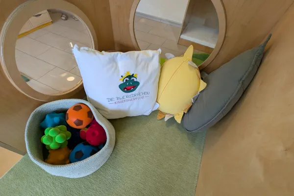 Bewegungsbereich mit weichen Kissen und Bällen für sichere Tobespiele und motorische Förderung