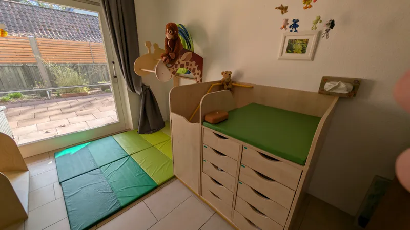 Sichere Wickelstation mit gepolsterten Matten und kindgerechten Kletterelementen für selbstständige Bewegungsentwicklung