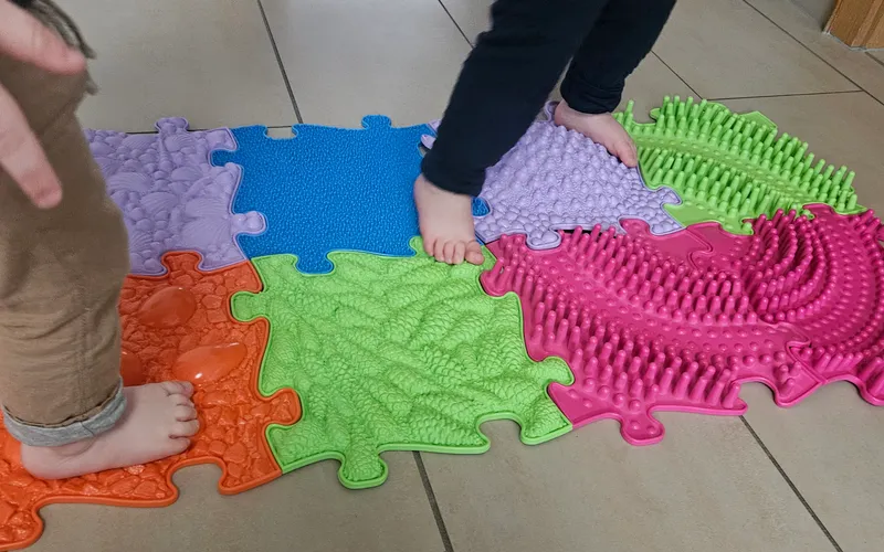 Kinder erkunden Sensorikmatten barfuß – taktile Sinneserfahrungen für 0-12 Monate