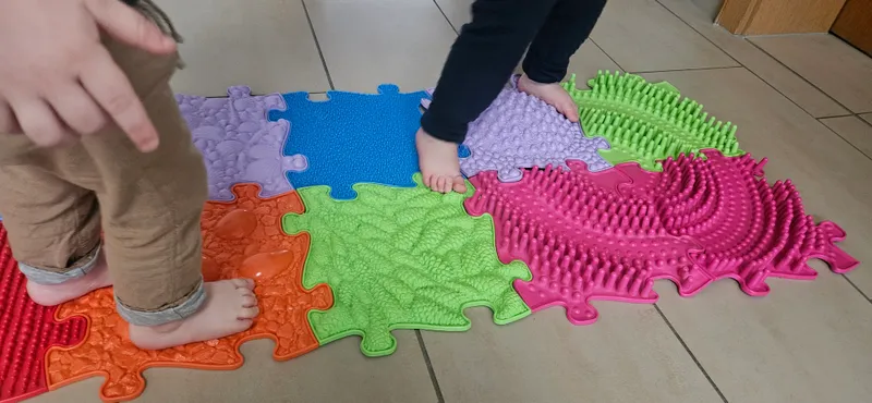 Kinder erkunden Sensorikmatten barfuß – taktile Sinneserfahrungen für 0-12 Monate